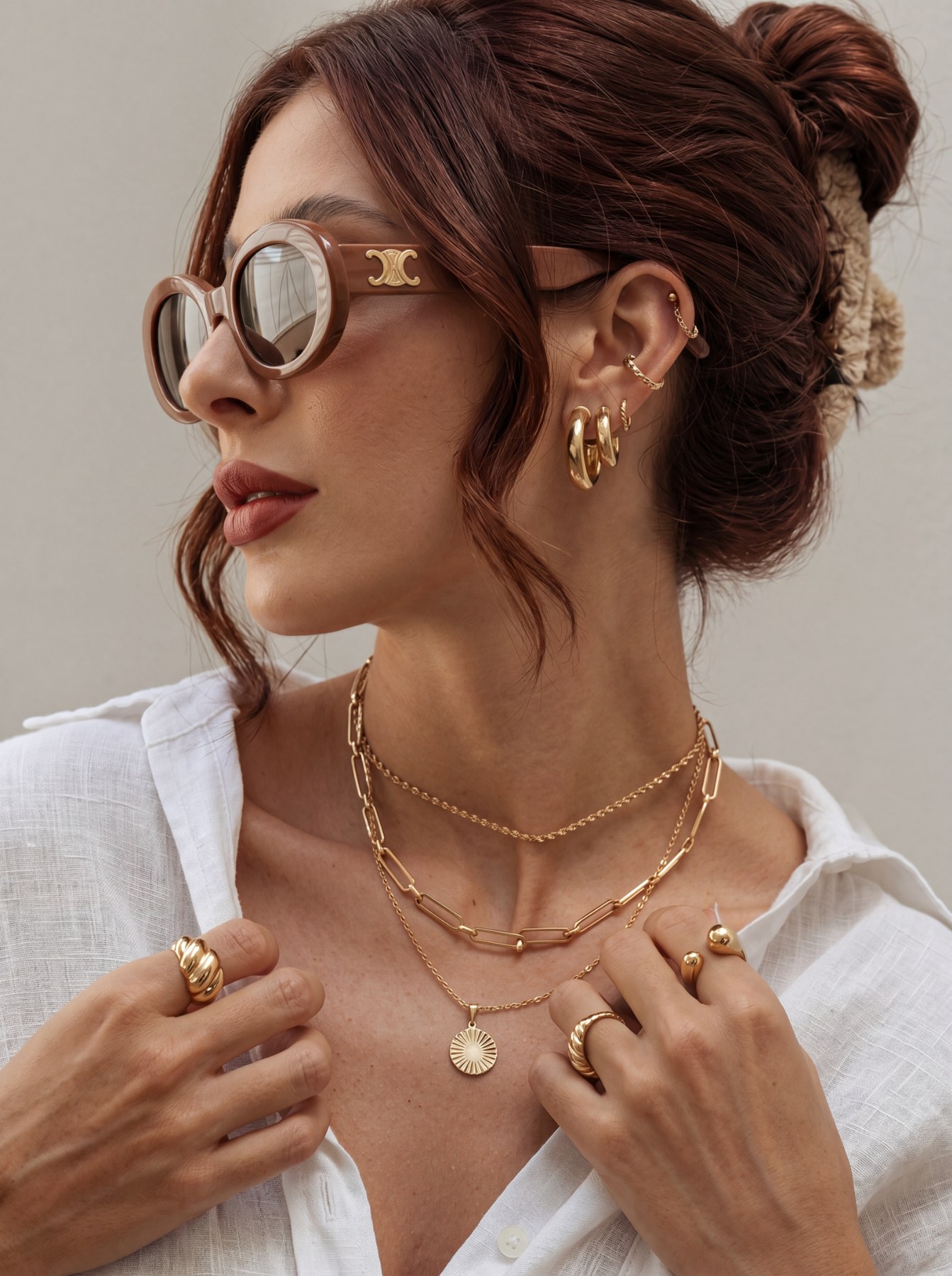 Close editorial portrait with layered gold jewelry, shine, and luxury attitude.